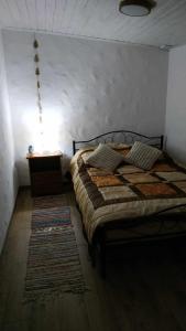 鲁恰内尼达Domek z kominkiem, Ukta 63, Mazury,的一间卧室配有一张床和一张带台灯的桌子