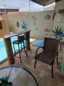 阿拉卡茹CASA próximo PRAIA para temporada的庭院配有两把椅子、一张桌子和一个柜台。
