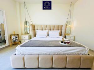 希马拉NaDar Luxury House - Green Coast的一间卧室配有一张大床和软垫床头板