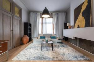 布鲁塞尔3 bedrooms apartement with enclosed garden and wifi at Bruxelles的带沙发和壁炉的客厅