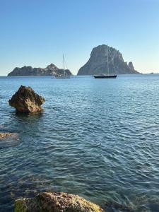 伊维萨镇Ibiza Camper Vans的两艘船在一大片水中,有岩石