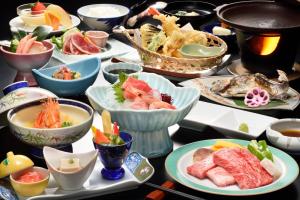 米泽市Tofuya Ryokan, Onogawa Onsen, Sauna, Barrier-free的盛满食物和碗的桌子