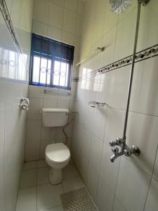RukungiriUnity Comfort Home的白色的浴室设有卫生间和窗户。