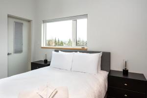怀特霍斯NN - The Flame - Downtown 1-bed 2-bath的卧室配有一张大白色床和窗户