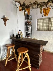 康塞普西翁德阿塔科Casaca的一间酒吧,在一间房间里设有两张木凳