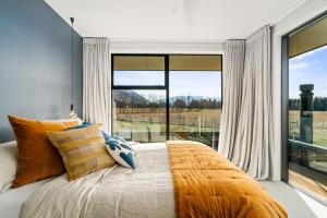 瓦纳卡Wanaka Luxury on Sutdholme的一间卧室设有一张床和一个大窗户