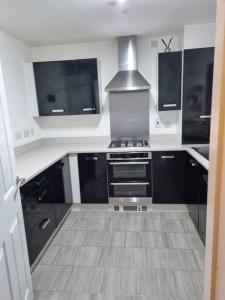 雷纳姆New Built Immaculate Condition的厨房配有黑色橱柜和炉灶。