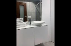 伊佐拉Apartments Artemus Karliva的浴室设有白色水槽和镜子