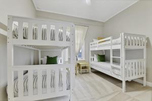 奥兰治Kinross Cottage Close to CBD Comfy & Convenient的白色客房内的2张白色双层床
