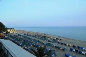 帕拉利亚卡泰里尼斯全景酒店的海滩上摆放着一把遮阳伞和椅子