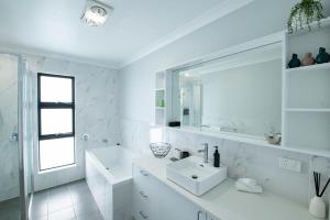 达博Cosy Retreat on Naman - Private & Convenient的白色的浴室设有水槽和镜子