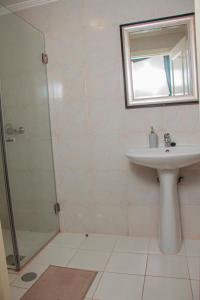 罗安达Studio 110的白色的浴室设有水槽和淋浴。