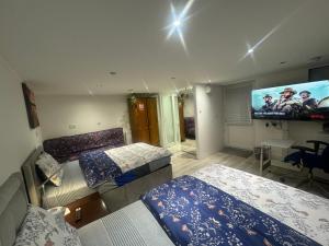 海斯North Avenue, Guest House, Heathrow Airport-Free Parking的一间卧室配有两张床和一台平面电视