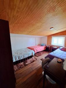 蒙特港Cabaña Alba的一间卧室设有两张床和木制天花板
