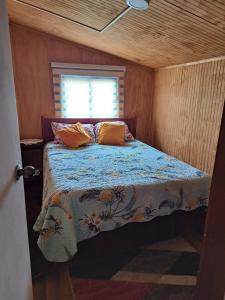 蒙特港Cabaña Alba的一个小房间的一个床位,设有窗户