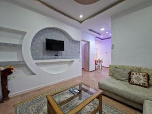 DjerbaRésidence Karim的客厅配有沙发和墙上的电视