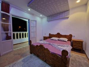 DjerbaRésidence Karim的一间卧室设有一张木床和一个窗户。