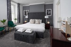 卡马森波尔斯黑德酒店的卧室配有一张白色大床和一张绿色椅子