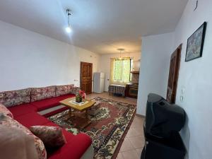 地拉那Shabani的客厅配有红色的沙发和桌子