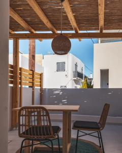 纳乌萨Alonia Suites的庭院配有木桌和两把椅子