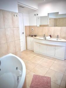 穆尔西亚Espectacular dúplex的浴室配有2个盥洗盆、浴缸和2个盥洗盆。