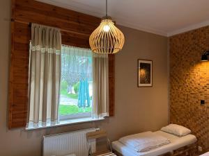 Wola MichowaLatarnia Wagabundy Bieszczady的客房设有带床和吊灯的窗户。