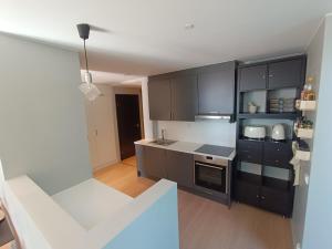 奥斯陆Barcode Oslo - Two-bedroom Apartment in Central Oslo的厨房配有黑色橱柜和白色台面