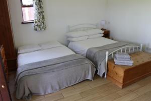 DilhorneMalthouse Farm Cottage Studio的一间卧室配有两张床和一张带毛巾的桌子。