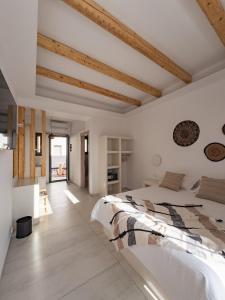 纳乌萨Alonia Suites的白色卧室设有大床和木制天花板