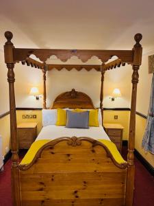 奇平诺顿王冠&靠垫酒店的一间卧室配有一张带黄色和蓝色枕头的木床。