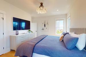 来特斯维比奇Oceans 12的一间卧室配有蓝色的床和吊灯。