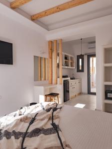 纳乌萨Alonia Suites的一间白色卧室,配有床和厨房
