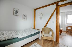 Hellenhahn-SchellenbergFerienwohnung Spatzennest的一间卧室配有一张床和一把椅子