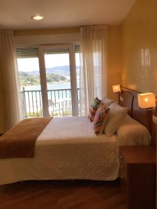 比韦罗阿拉米达酒店的一间卧室设有一张大床和大窗户