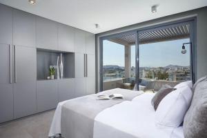 雅典CW Athens Riviera Suite的卧室配有白色的床和大窗户