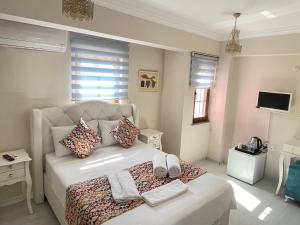 博兹贾阿达岛Ada Olympos Otel的一间卧室配有带毛巾的床
