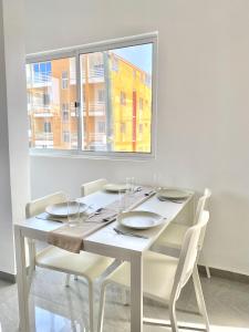 Pedra BadejoVila de Santiago Apartment的白色的餐桌、椅子和窗户