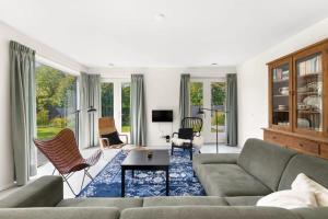 栋堡NEW Hello Zeeland - Vakantiehuis Jhr De Casembrootplein 19的带沙发、椅子和窗户的客厅
