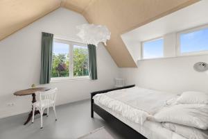 栋堡NEW Hello Zeeland - Vakantiehuis Jhr De Casembrootplein 19的一间卧室配有一张床、一张桌子和一个窗户。