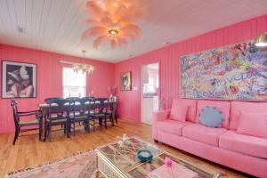 默特尔比奇Inn the Pink One-in-a-Million Vacation Home的粉红色的客厅配有粉红色的沙发和桌子
