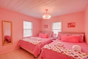 默特尔比奇Inn the Pink One-in-a-Million Vacation Home的配有粉红色墙壁的客房内的两张床