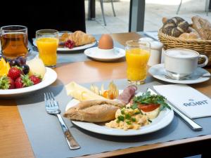 波鸿ACHAT Hotel Bochum Dortmund的餐桌,带食物盘和橙汁杯