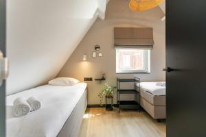 栋堡Hello Zeeland - Vakantiehuis Herenstraat 1A的小房间设有两张床和窗户