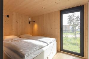 韦斯特卡佩勒Hello Zeeland - Zeeuwse Liefde Tiny House 8的窗户客房内的一张床位