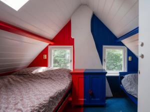 HengstdijkHello Zeeland - Vakantiewoning 't Schrijvershuisje的红色和蓝色的卧室设有床和2个窗户