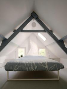 HengstdijkHello Zeeland - Vakantiewoning 't Schrijvershuisje的阁楼上的卧室配有一张大床