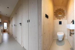 韦斯特卡佩勒Hello Zeeland - Tiny House Zeeuwse Liefde 6的一间带白色橱柜和卫生间的浴室