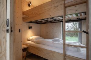 韦斯特卡佩勒Hello Zeeland - Tiny House Zeeuwse Liefde 6的带窗户的客房内的双层床