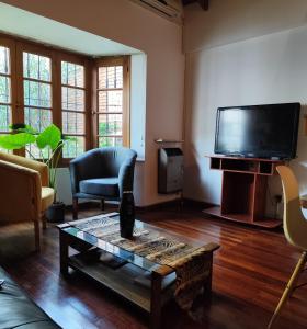 门多萨Tanino Home Suites的客厅配有电视和茶几