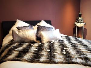 沙勒罗瓦Symbiose hotel的一张带黑白毯子和枕头的床